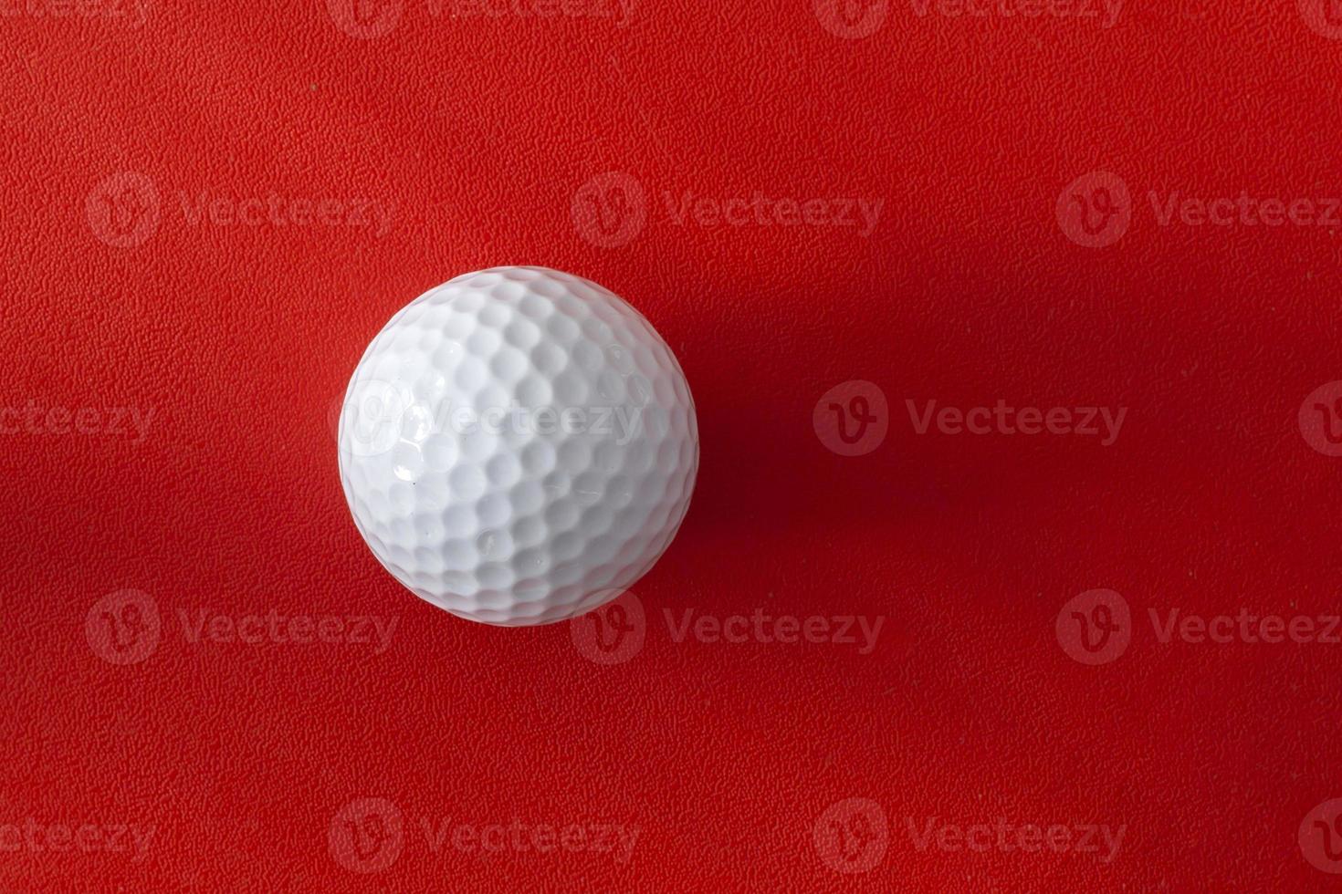 bola de golfe em um fundo vermelho foto