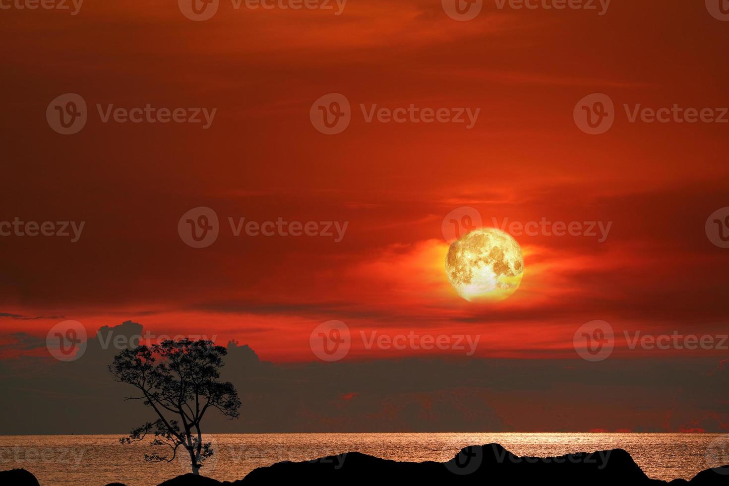 lua de sangue e árvore na montanha silhueta no céu pôr do sol foto