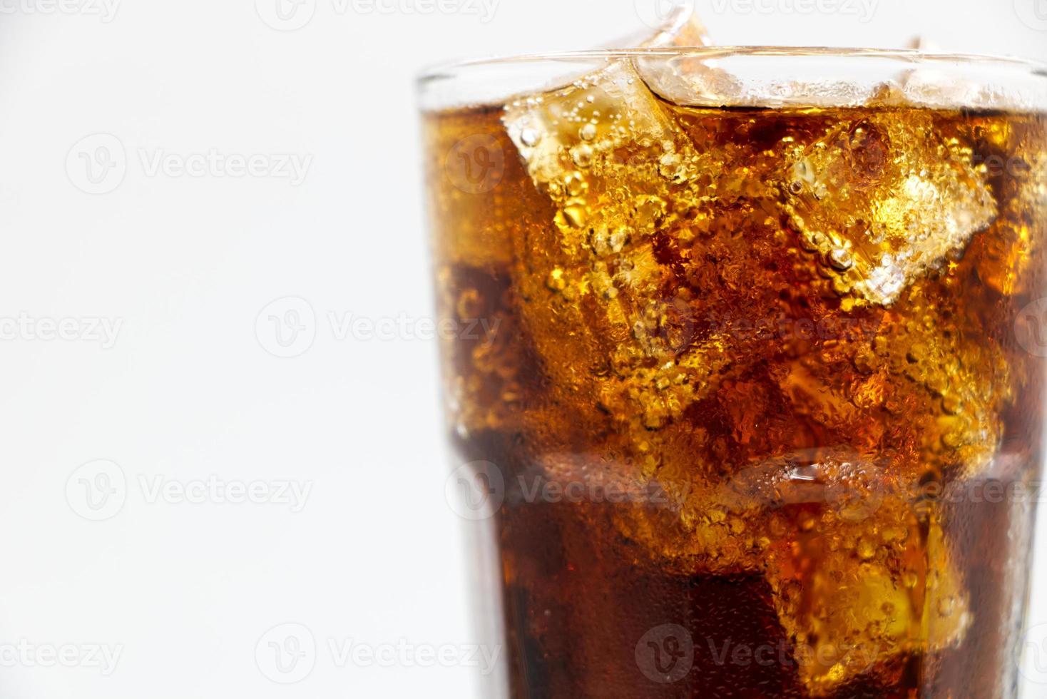 copo de cola com esmagado em um fundo branco gelo de cola em vidro e há gotas de água ao redor. bebida fresca preta fresca. foto