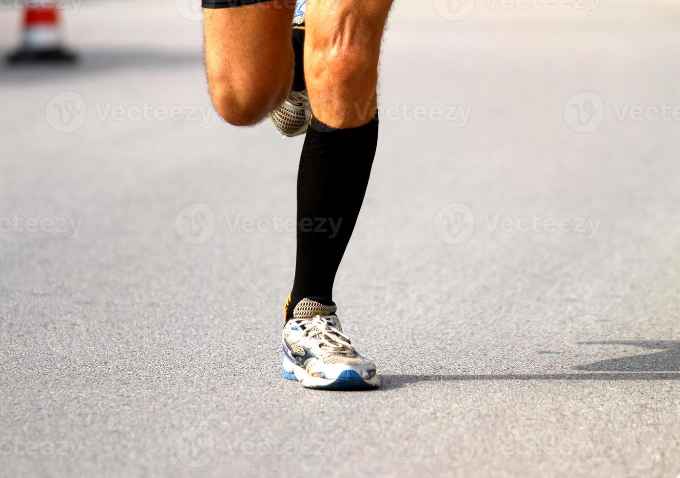 corredor rápido com tênis durante a maratona na estrada foto