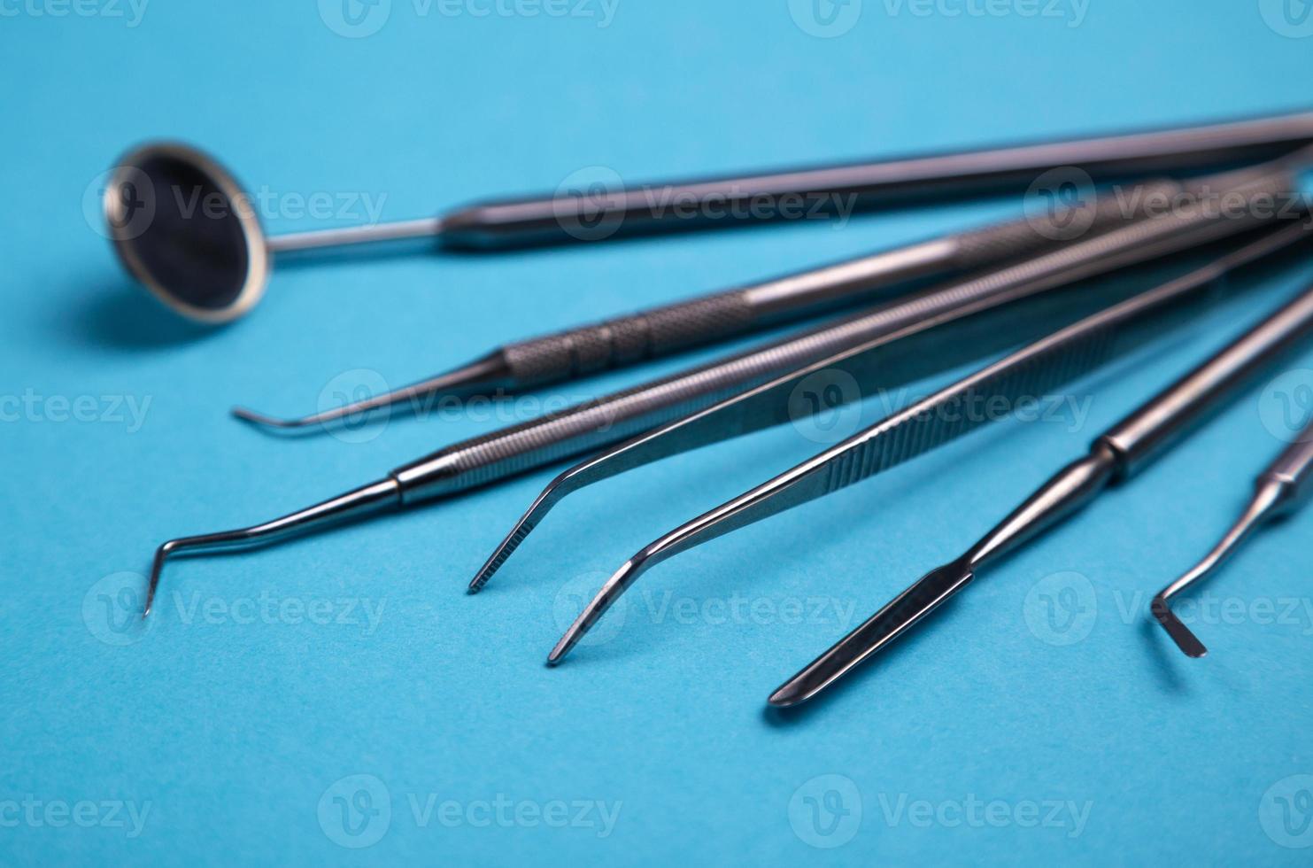 conjunto de instrumentos odontológicos em um fundo azul. foto