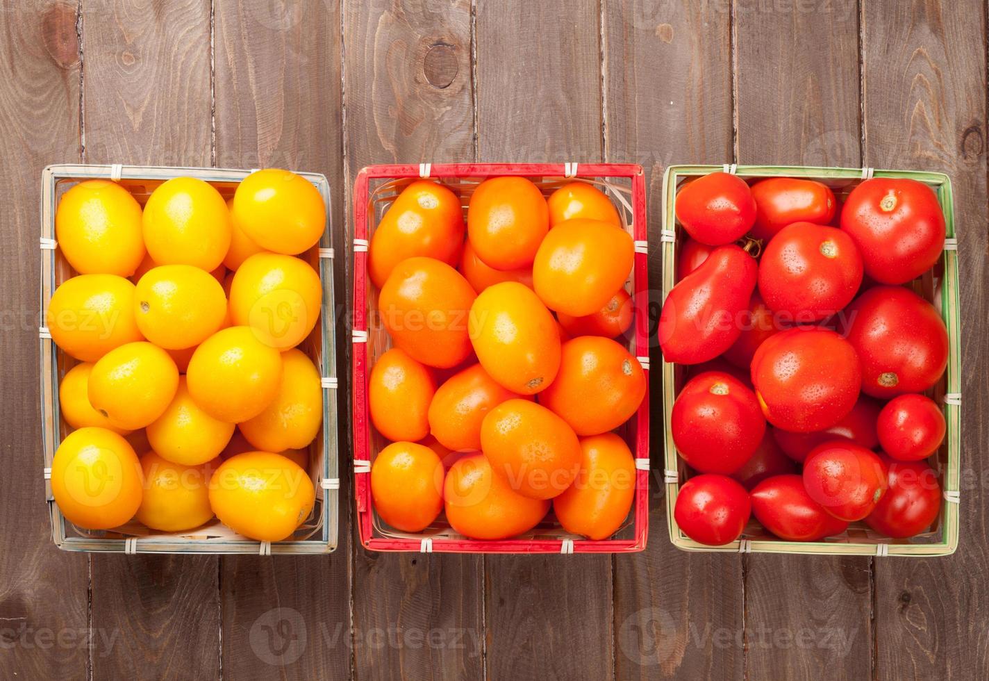 tomates coloridos na mesa de madeira foto