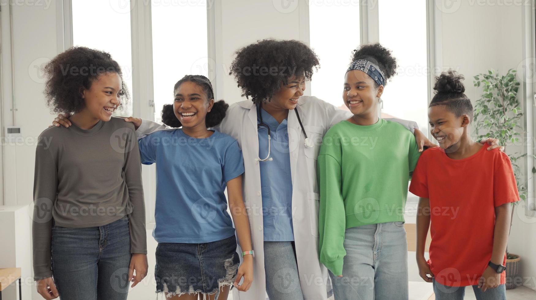 médico americano africano e crianças rindo no hospital ou clínica. foto