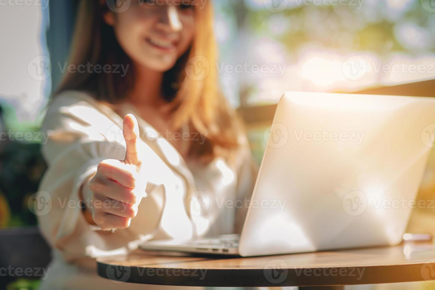 close-up de empresária mostrando os polegares para cima Cadastre-se no escritório em seu local de trabalho. foco selecionado foto