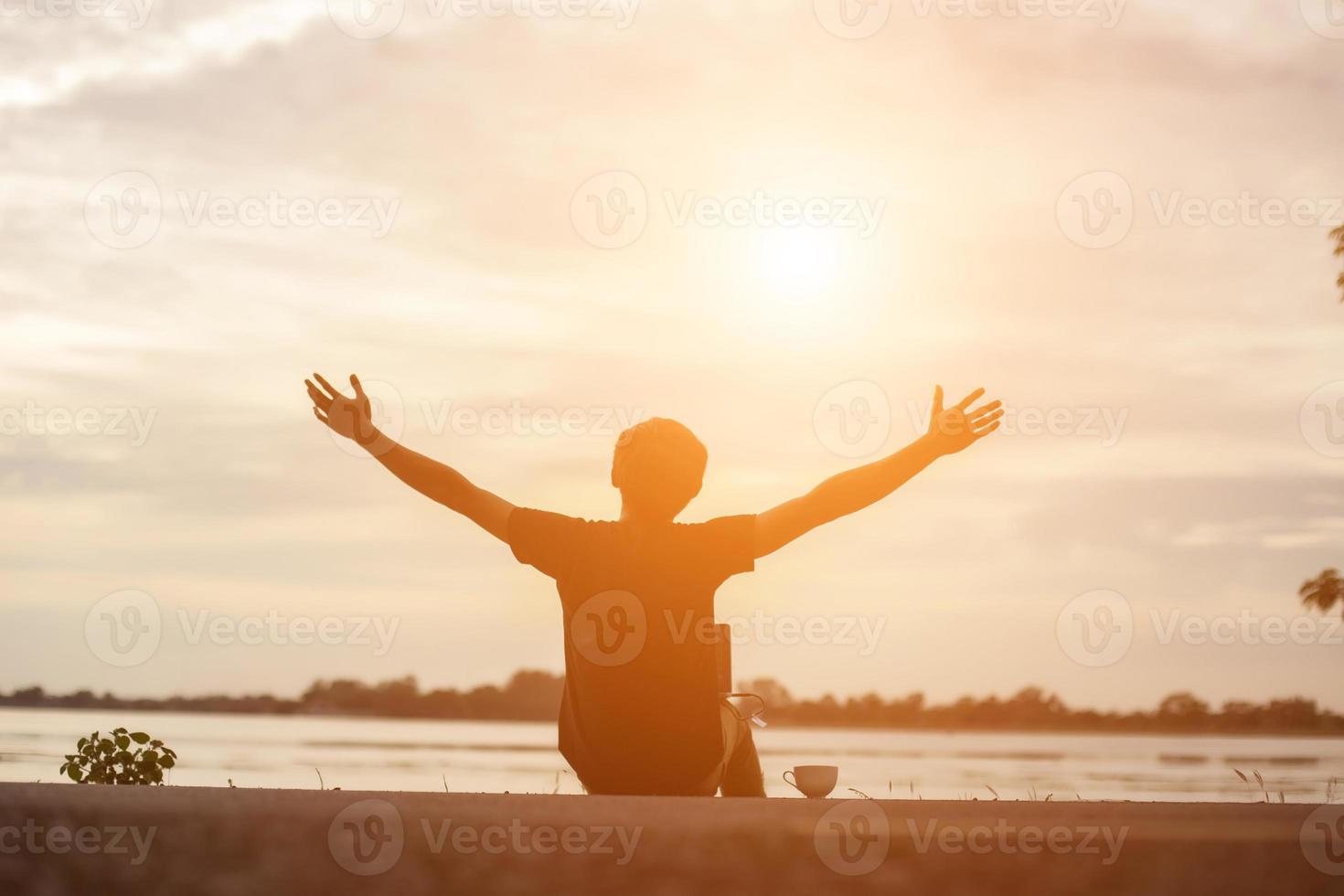 esportista de sucesso, levantando os braços no céu dourado, iluminação por do sol, verão, após a corrida cruzada. atleta masculino de fitness com os braços para cima comemorando objetivos após o esporte se exercitando e malhando ao ar livre. foto