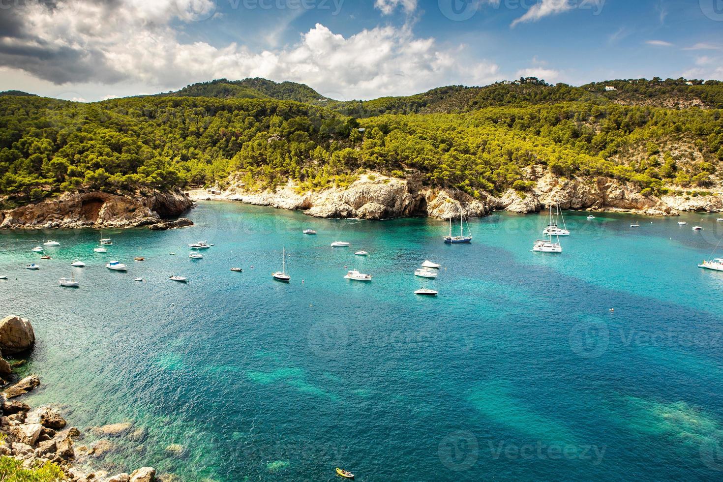 bela praia com água muito limpa e azul no mar mediterrâneo na ilha de ibiza, espanha foto