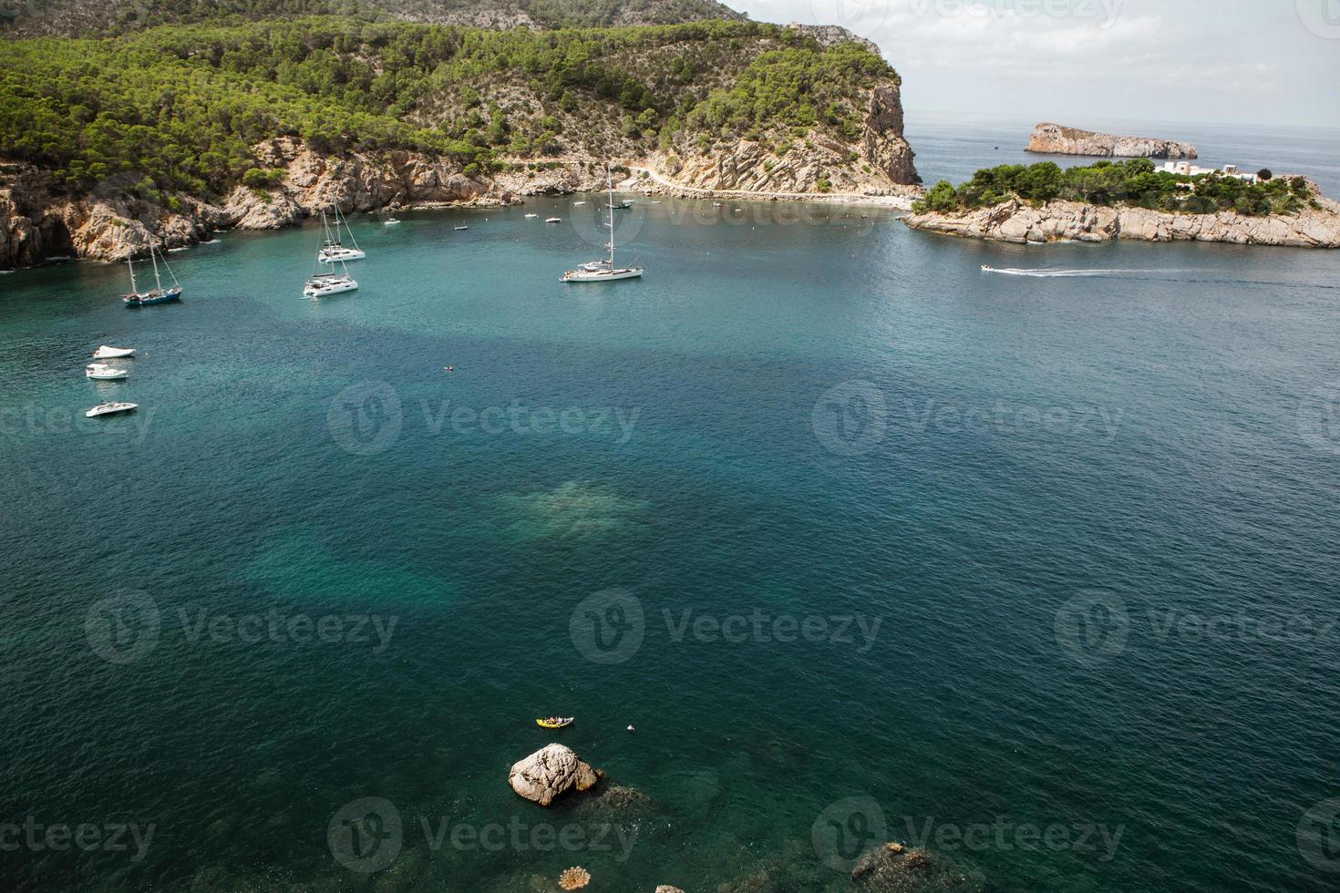 bela praia com água muito limpa e azul no mar mediterrâneo na ilha de ibiza, espanha foto