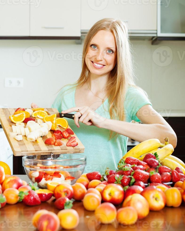 mulher cozinhando salada de frutas foto
