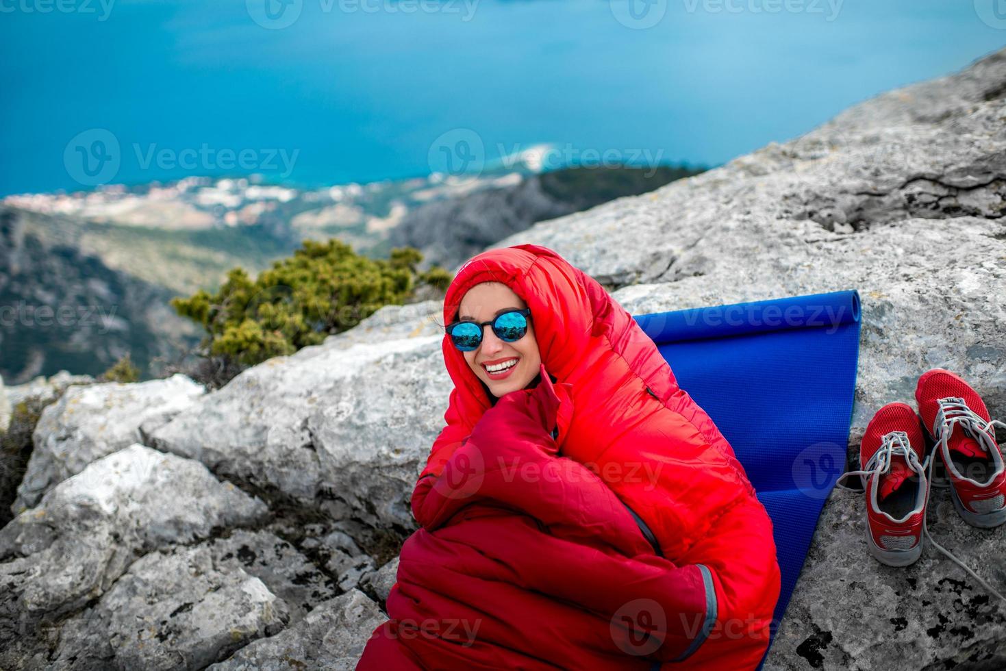 mulher em saco de dormir na montanha foto