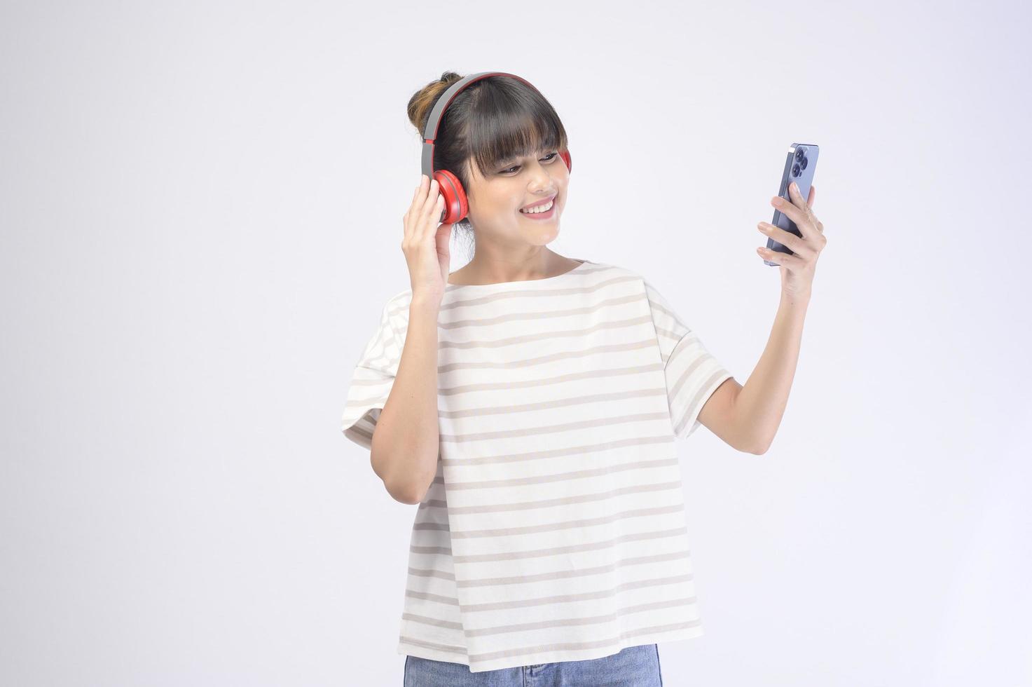 jovem mulher bonita usando fone de ouvido em fundo branco foto