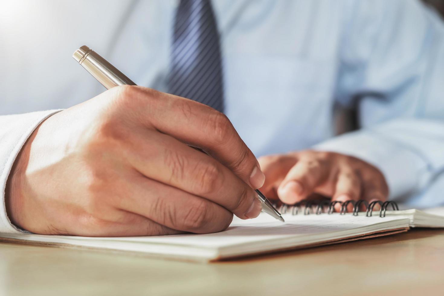 empresário escrevendo no caderno no escritório foto