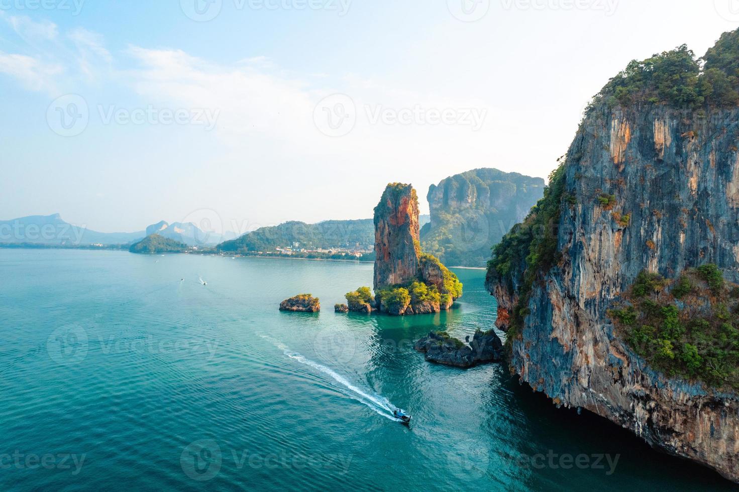 vista para o mar e ilhas rochosas com um barco de cauda longa. foto