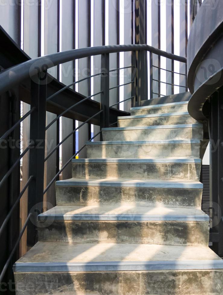 a escada em espiral de concreto com o corrimão de metal. foto