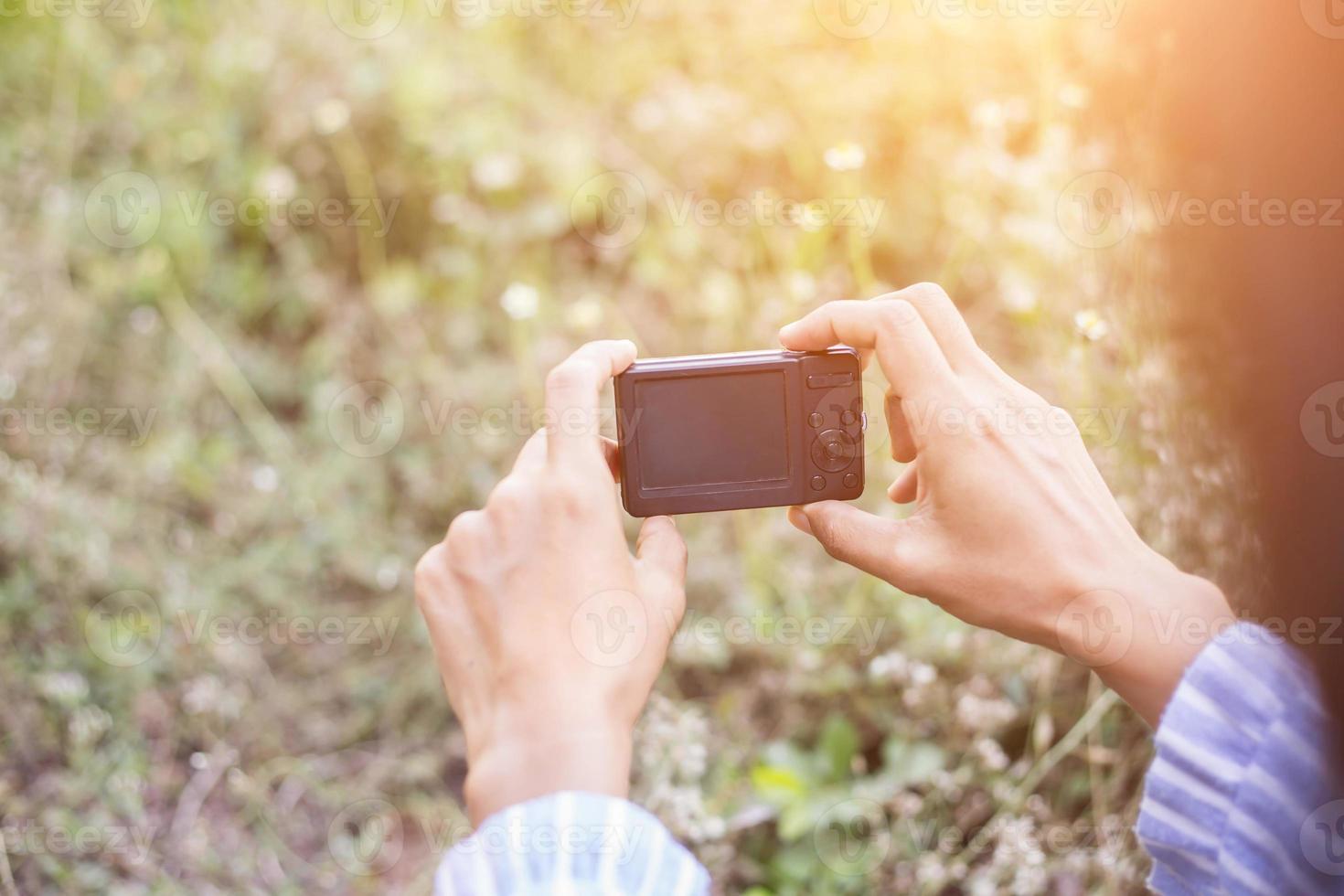 menina fotografa flor ao ar livre foto