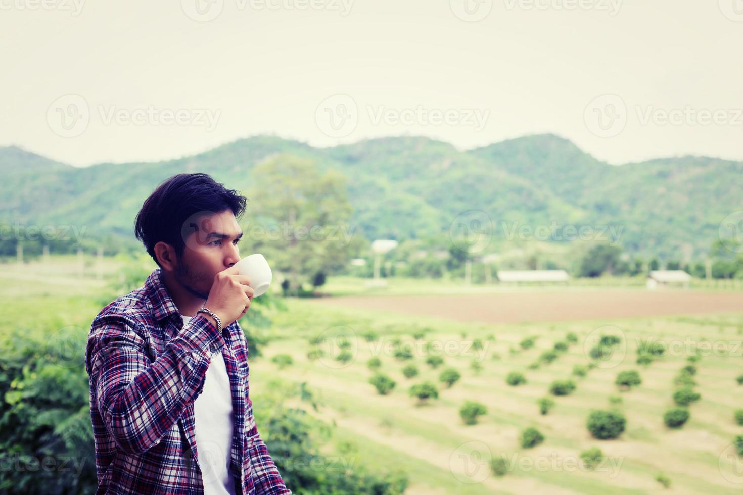 homem barbudo hipster bonito com café da manhã andando no parque. foto