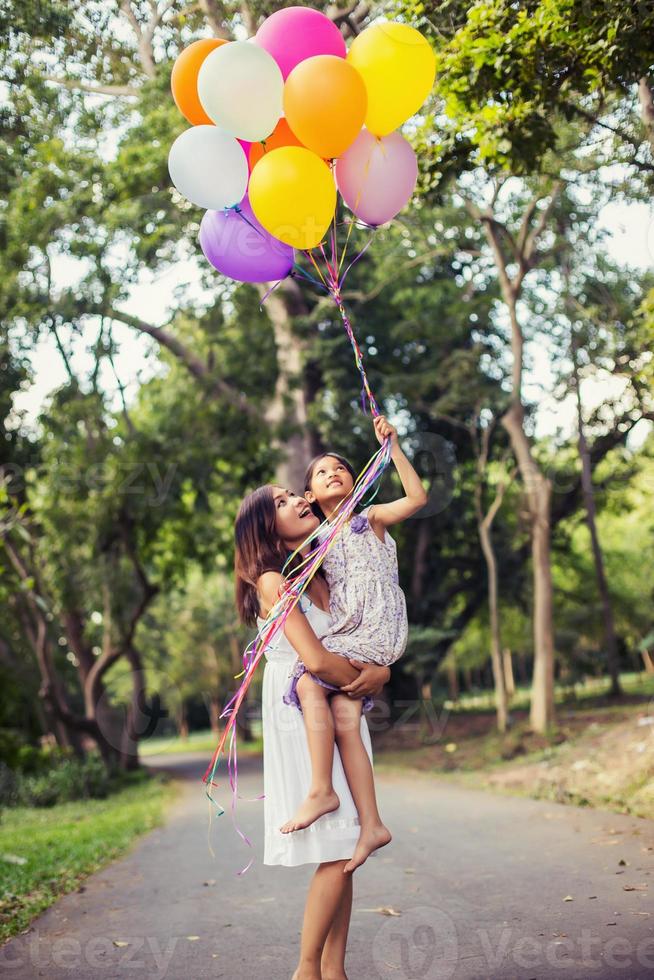 mãe carregando sua filha com a natureza e a luz do sol, família de diversão. foto