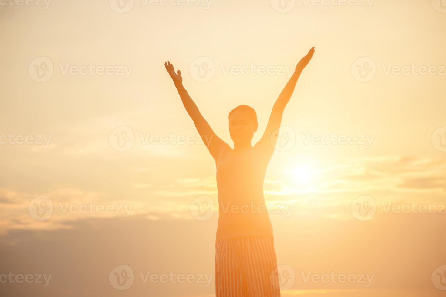 jovem levanta as mãos para seu sucesso, conceito de sucesso na vida. foto