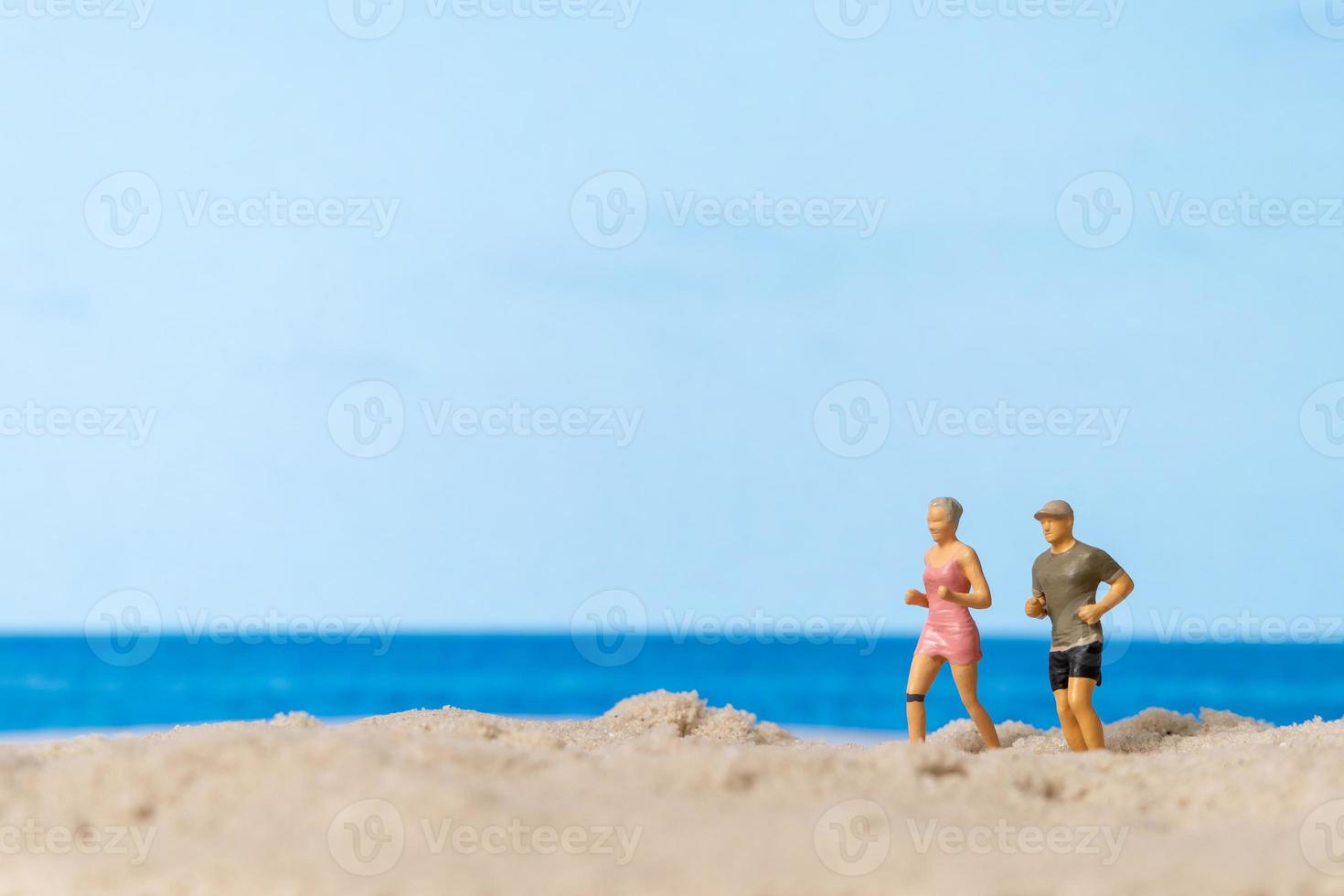 casal em miniatura correndo juntos na praia foto