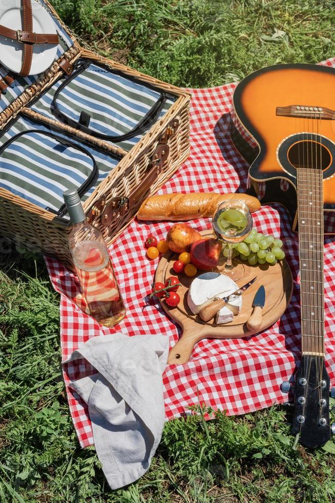 closeup de cesta de piquenique com bebidas e comida na grama foto