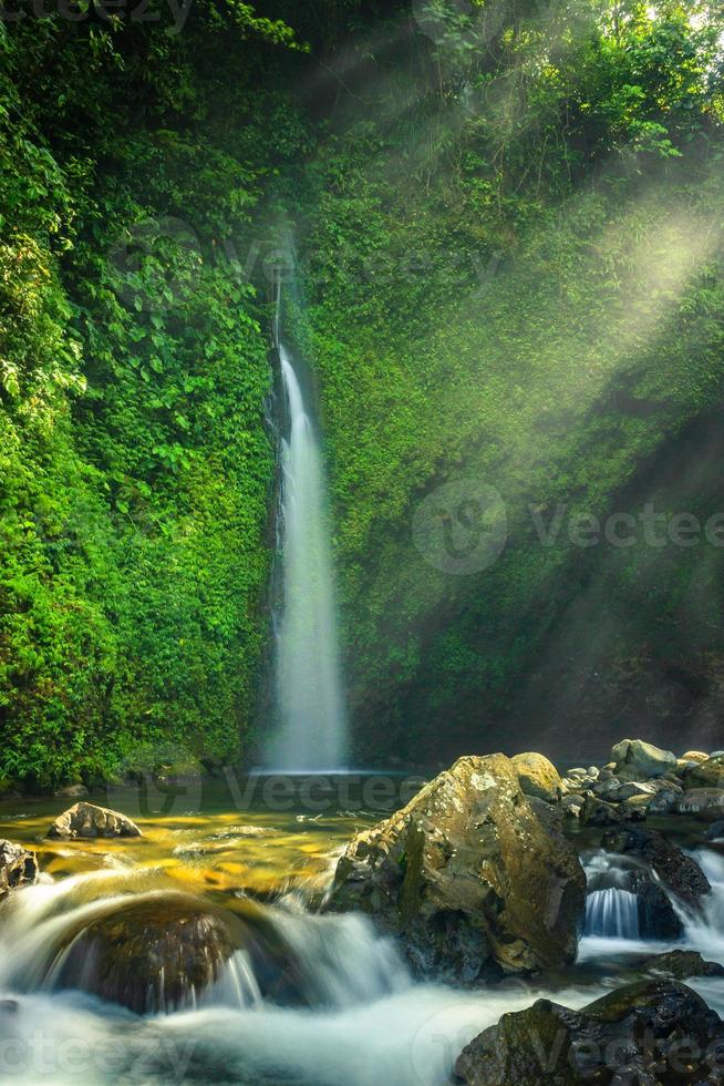 vista da manhã na bela cachoeira com sol brilhando foto