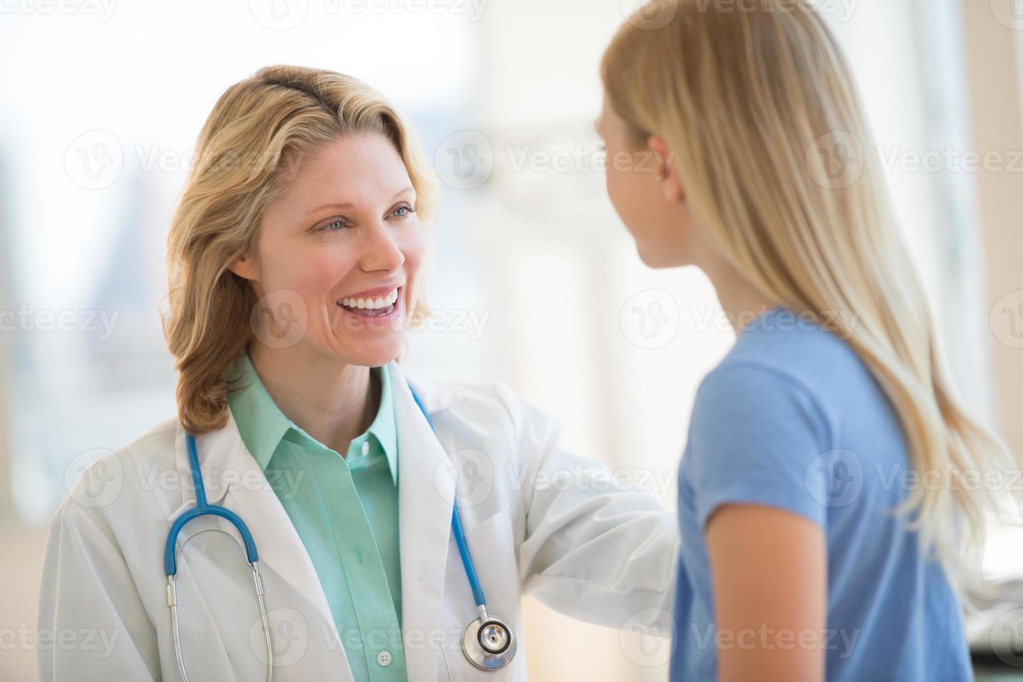 médica olhando a garota na clínica foto