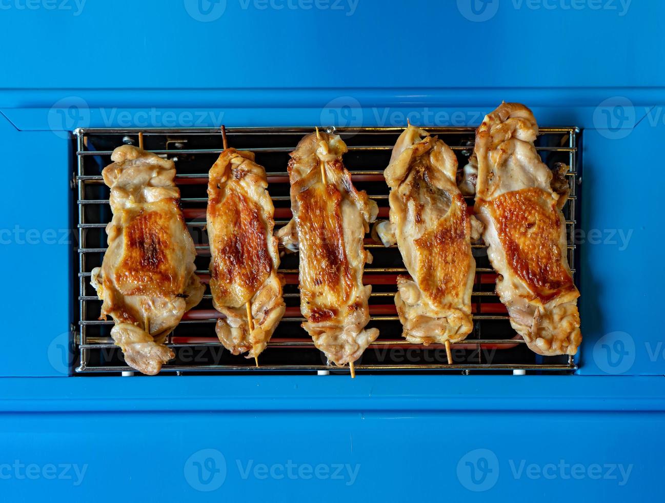 frango grelhado no fogão elétrico azul liso da vista superior para um fundo alimentar simples e mínimo foto
