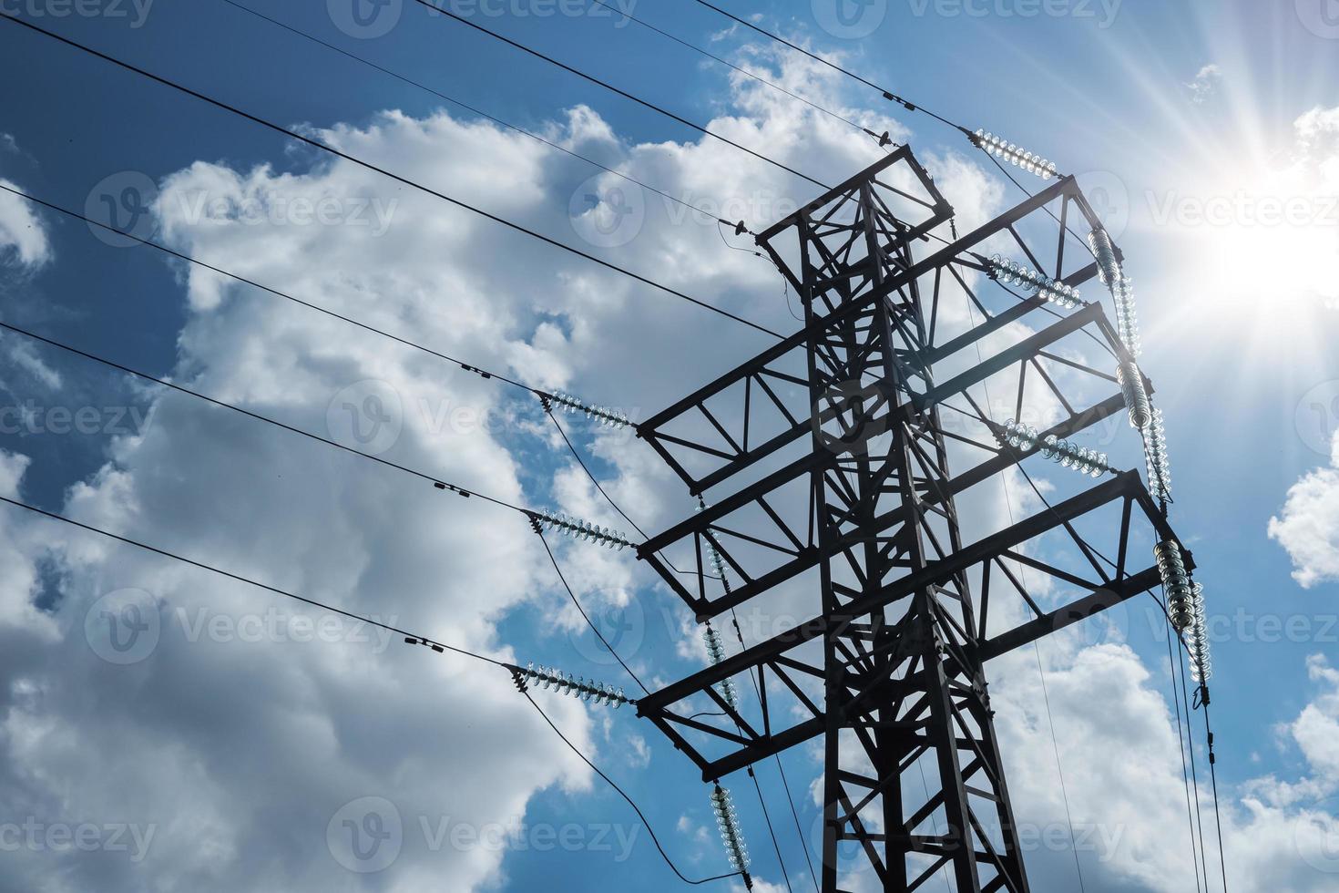 torre de canto de transmissão elétrica de alta tensão no contexto de um céu nublado com raios de sol. foto