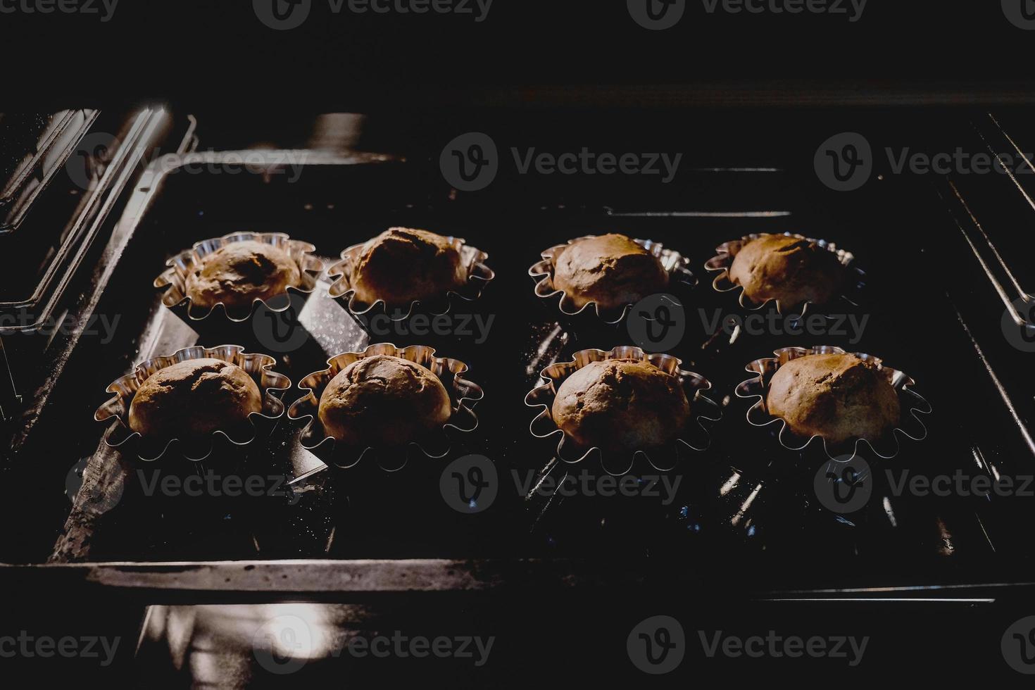 close-up de muffins de chocolate assando no forno foto