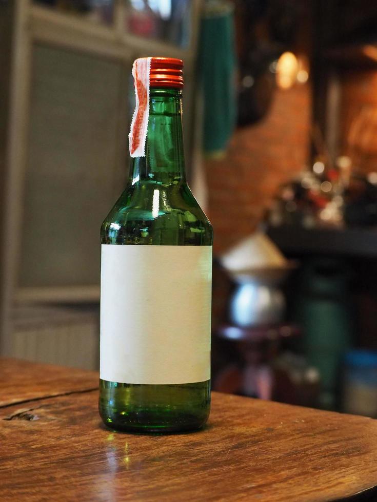 garrafa de cerveja com rótulo em branco na mesa de madeira foto