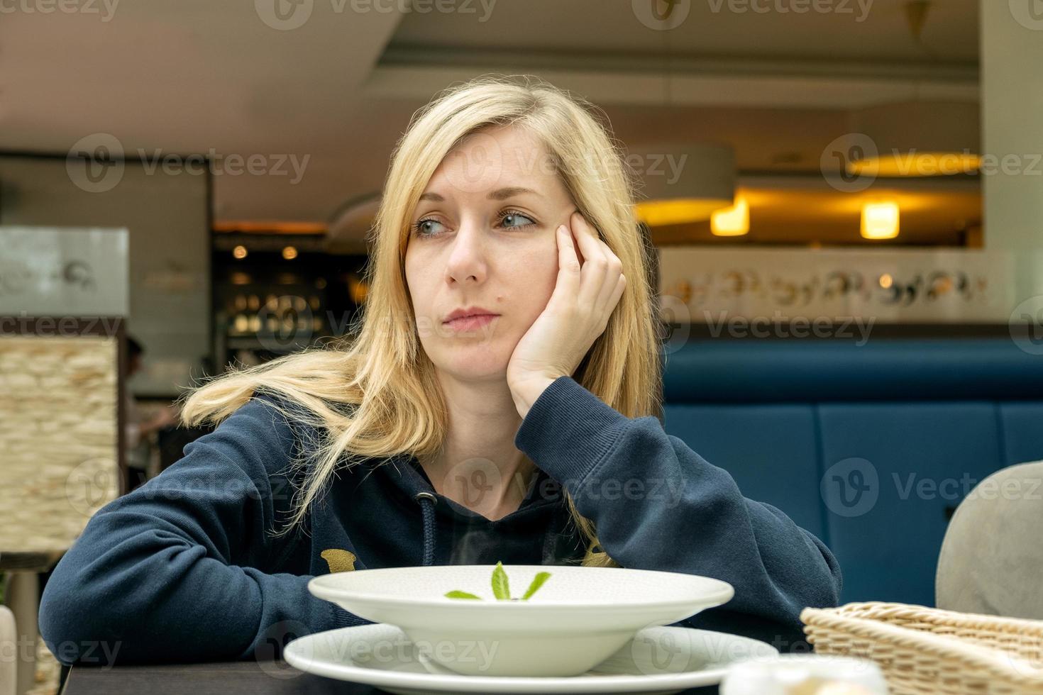 mulher loira em um café com um prato de comida foto