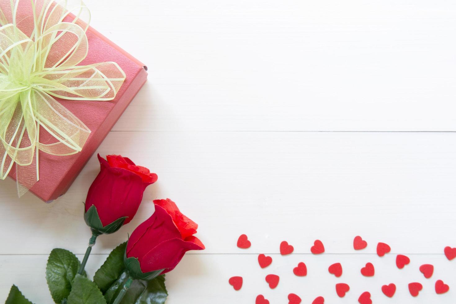 presente presente com flor rosa vermelha e caixa de presente com fita de laço e coração na mesa de madeira, 14 de fevereiro do dia do amor com romântico, conceito de férias dos namorados, vista superior. foto