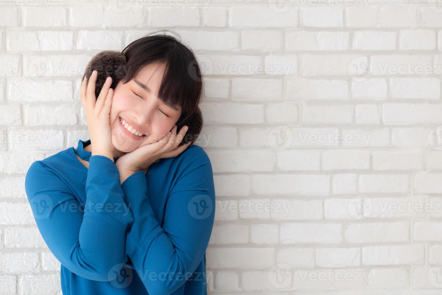 retrato de uma bela jovem asiática desfrutar e felicidade em pé no fundo de tijolo de parede grunge de textura de cimento cinza, a garota é uma sorridente e alegre no concreto. foto