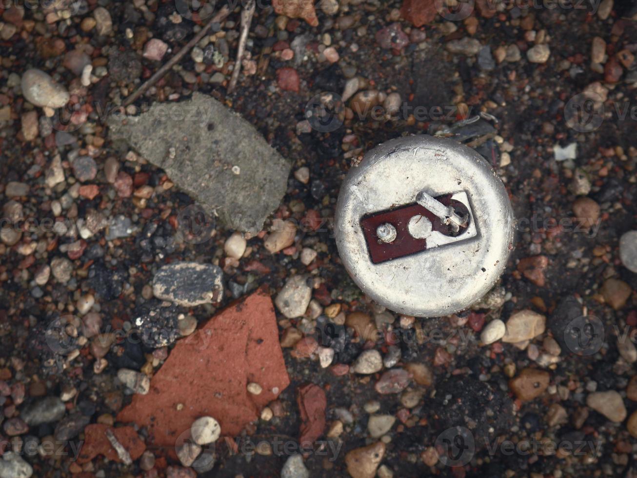 interruptor de metal de aço corroído velho com alavanca deitada no chão preto no lixo com peças de tijolos vermelhos quebrados e seixos foto
