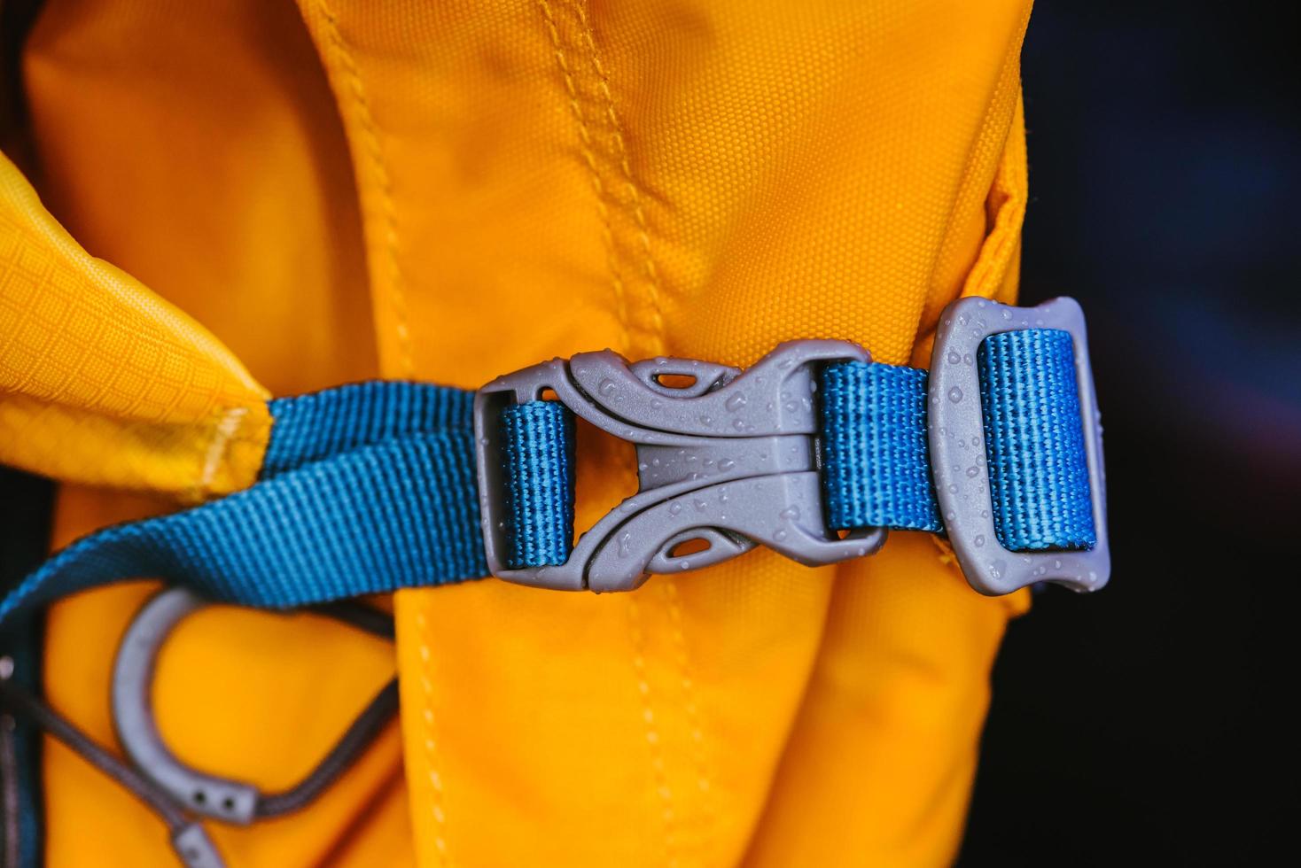 detalhe de close-up de fecho de plástico conveniente azul trancado de mochila amarela. foto