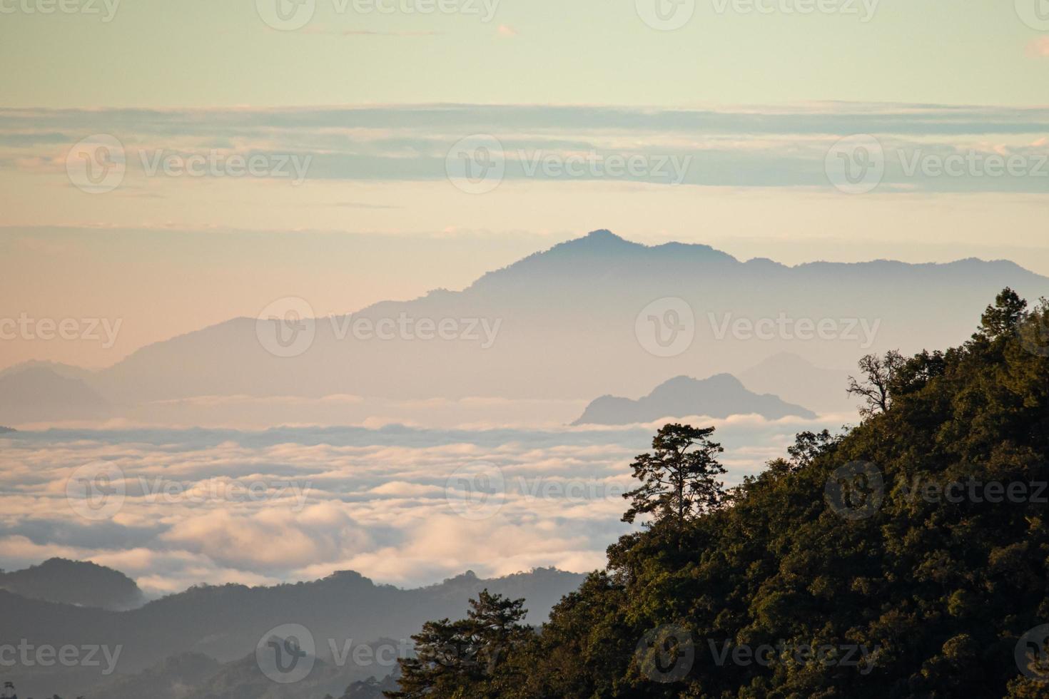 paisagem montanhosa do nascer do sol colorido nas montanhas. ver em nevoeiro e nuvem foto