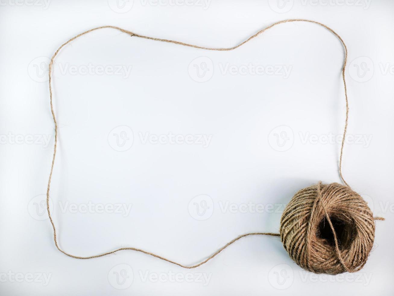corda crua enrolada feita de várias fibras em uma corda longa. é esticado em um quadro com um espaço para inserir texto no meio para artesanato marrom, fundo branco isolado, tiro em estúdio. foto