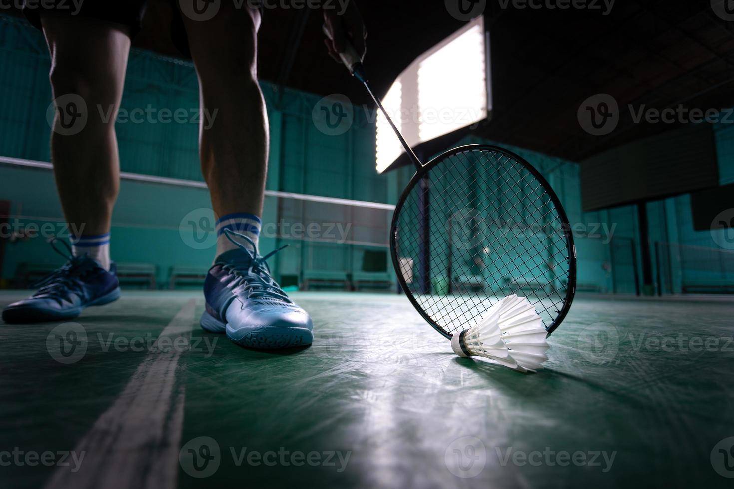 bola de badminton ou peteca com raquete de badminton no tribunal com jogador profissional de badminton jogar no tribunal no ginásio para competição de campeonato saudável e esportiva foto