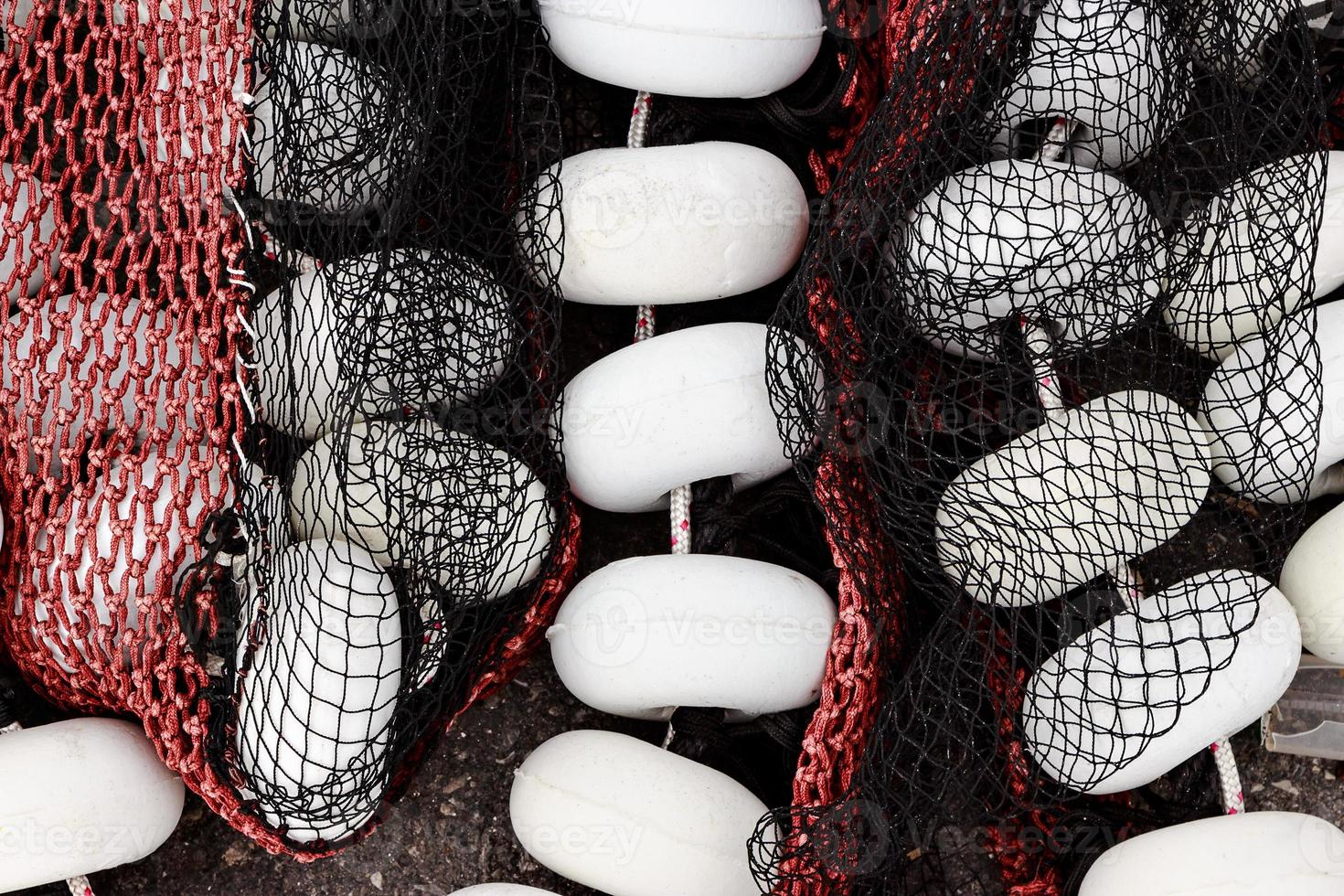 rede de pesca preta e vermelha com rolhas brancas no porto de santona, cantábria, espanha. imagem horizontal. foto