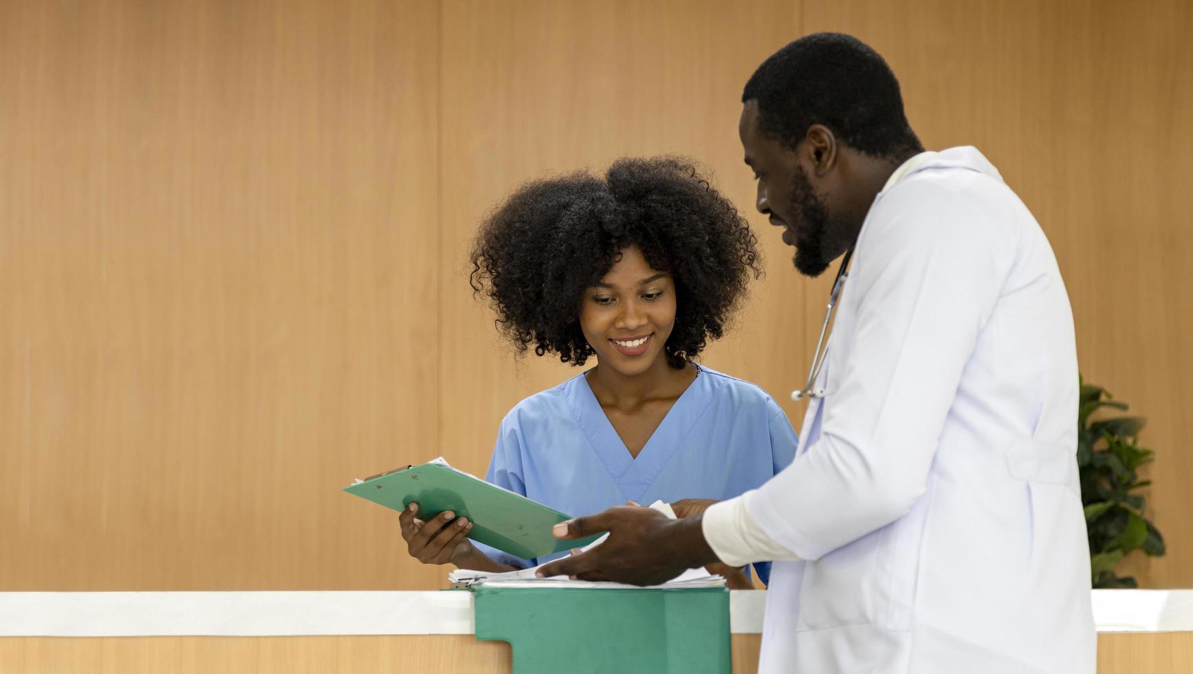 equipe de médicos e enfermeiros afro-americanos está discutindo e debatendo sobre o prontuário do paciente após o diagnóstico para um plano de cuidados preciso com o conceito experiente de especialista médico sênior foto