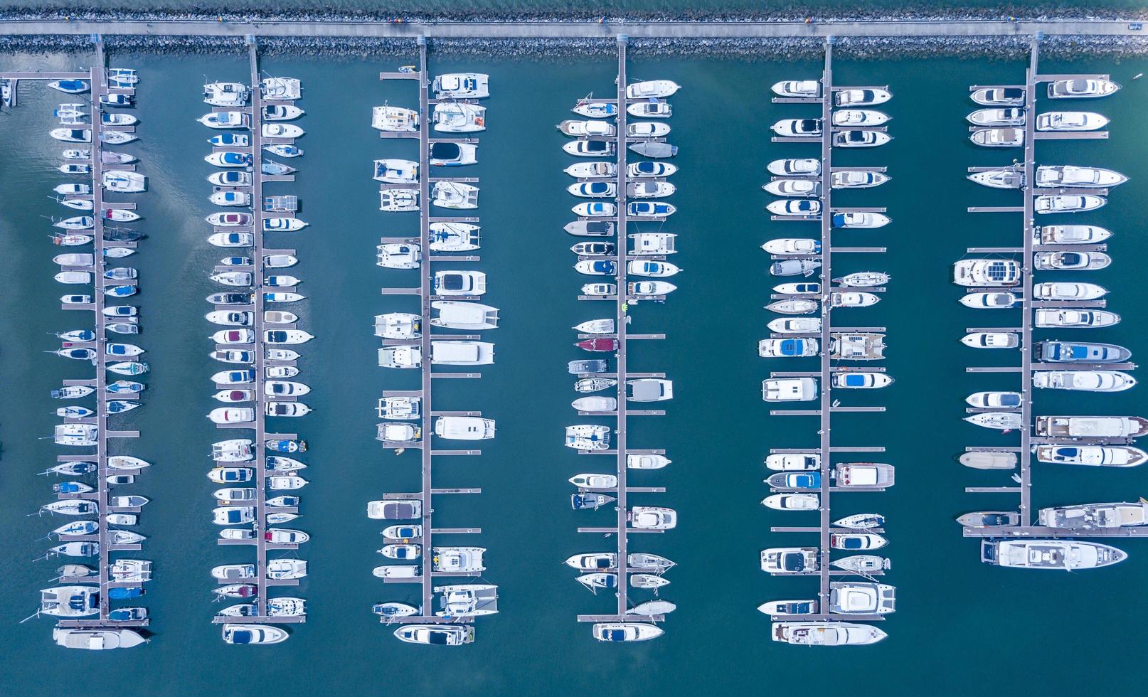 porto marítimo para iate, lancha, serviço de estacionamento de veleiros e amarrações para milionários de luxo e ricos em vista aérea com muitos navios ancorados ao longo da baía das docas foto