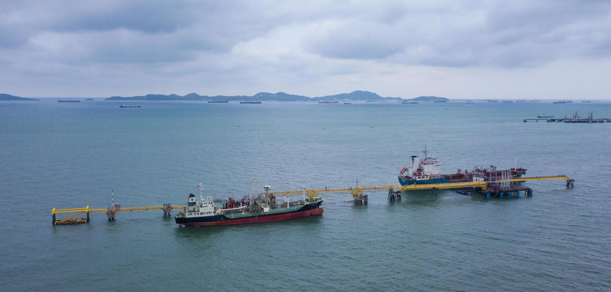 navio-tanque de carga, plataforma de atracação de navios marítimos e ancoradouro ultramarino para a indústria de petróleo e petróleo bruto a partir de vista aérea foto