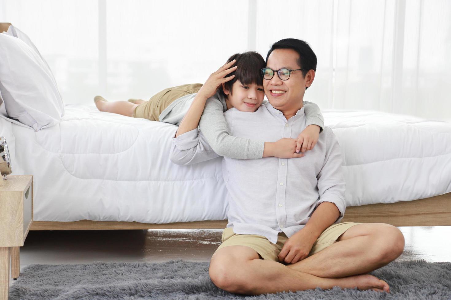 pai e filho asiáticos passando um tempo memorável juntos durante o fim de semana no quarto confortável foto