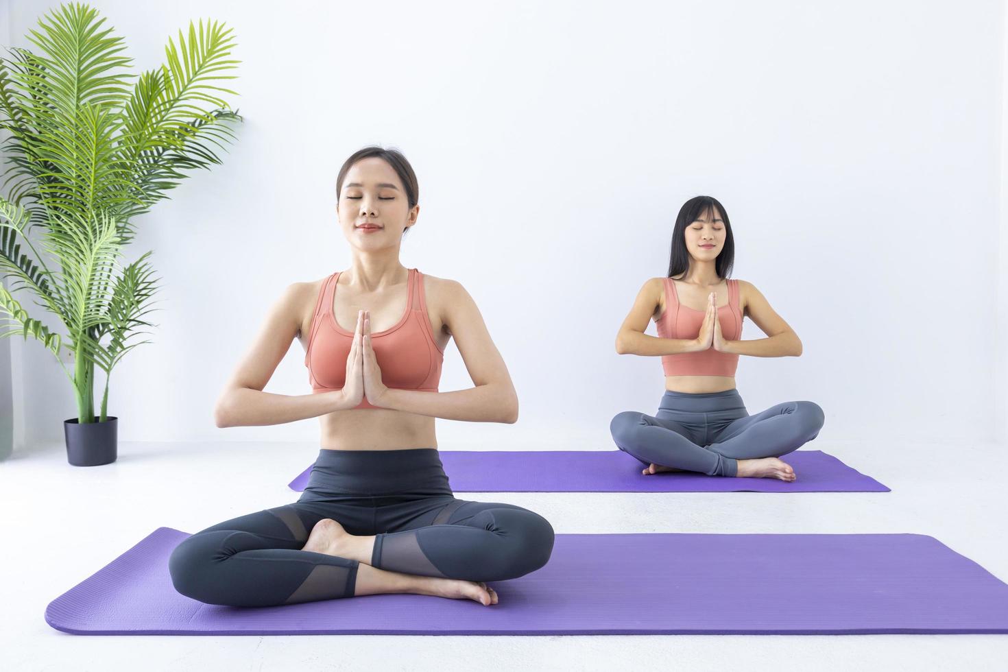 mulher asiática praticando ioga indoor com posição fácil e simples para controlar a inspiração e expiração em pose de meditação foto