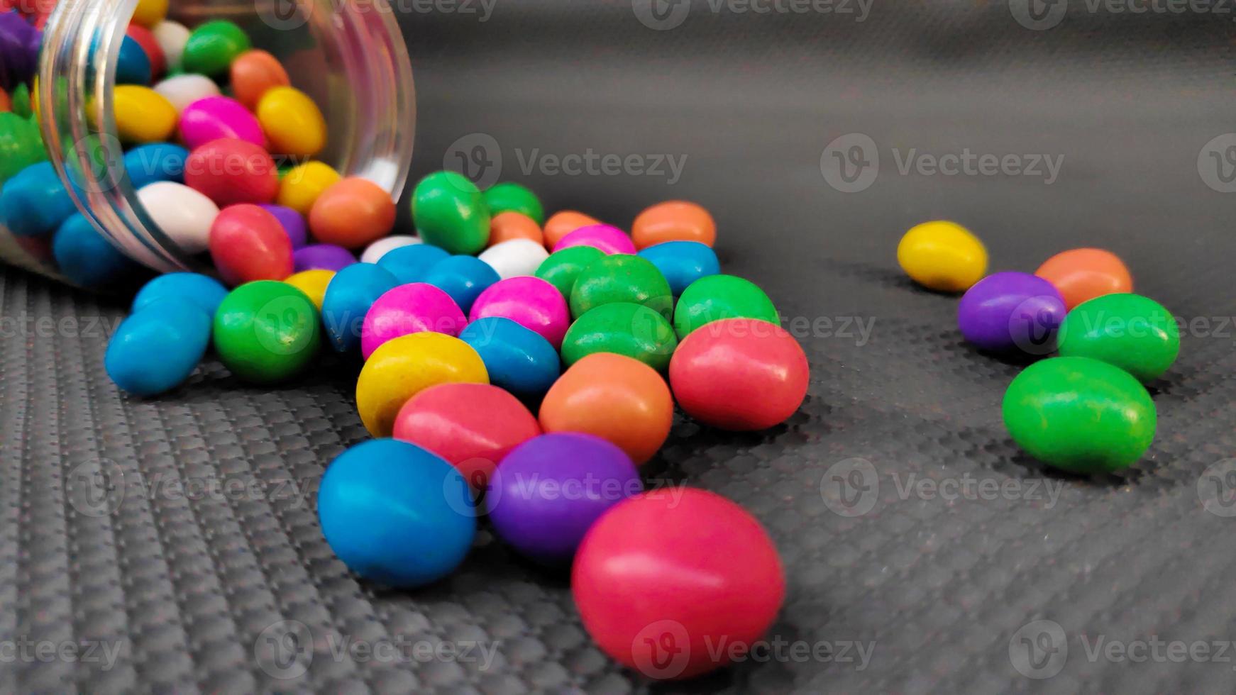 pilha de doces coloridos em um recipiente foto