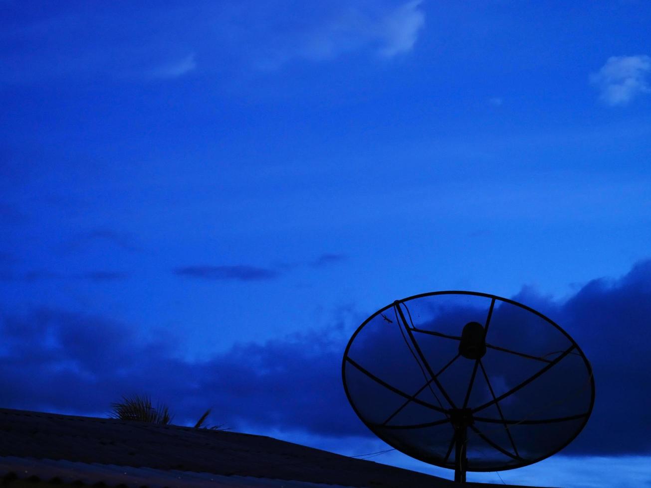 a antena parabólica foi instalada na casa à noite. foto