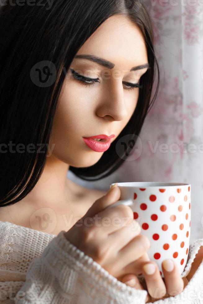 linda garota tomando café pela janela foto
