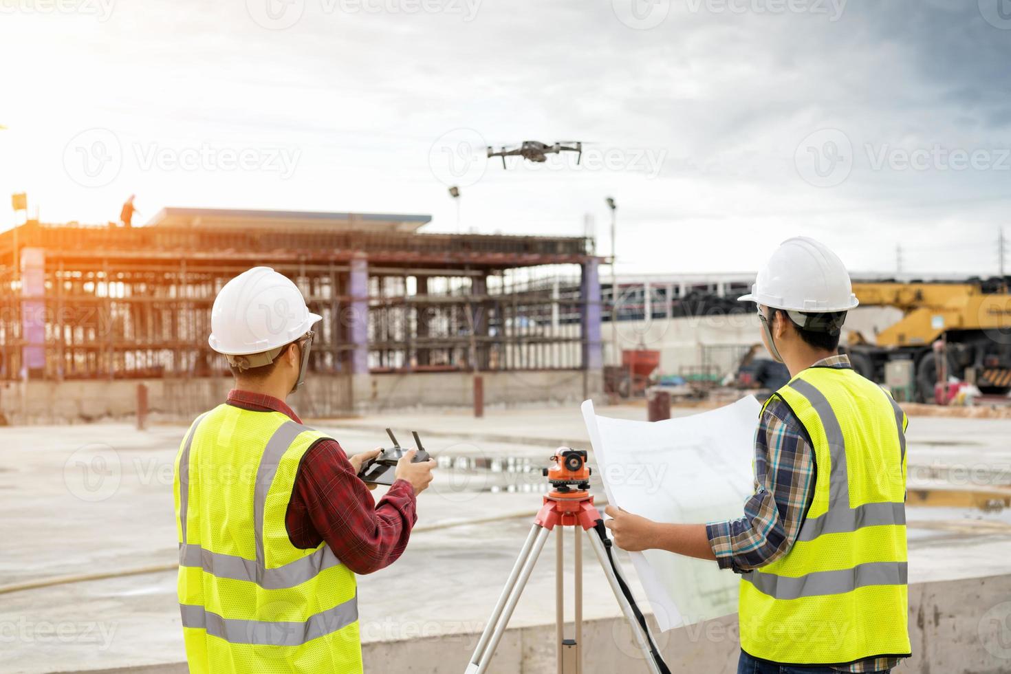 agrimensor de engenheiro trabalhando com teodolito no canteiro de obras foto