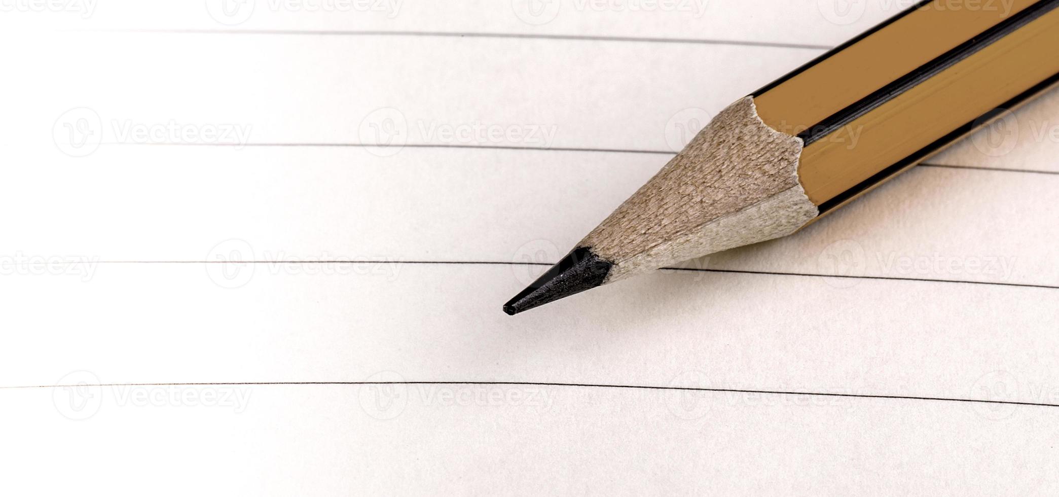 ponta de lápis em papel pautado branco. foco seletivo foto