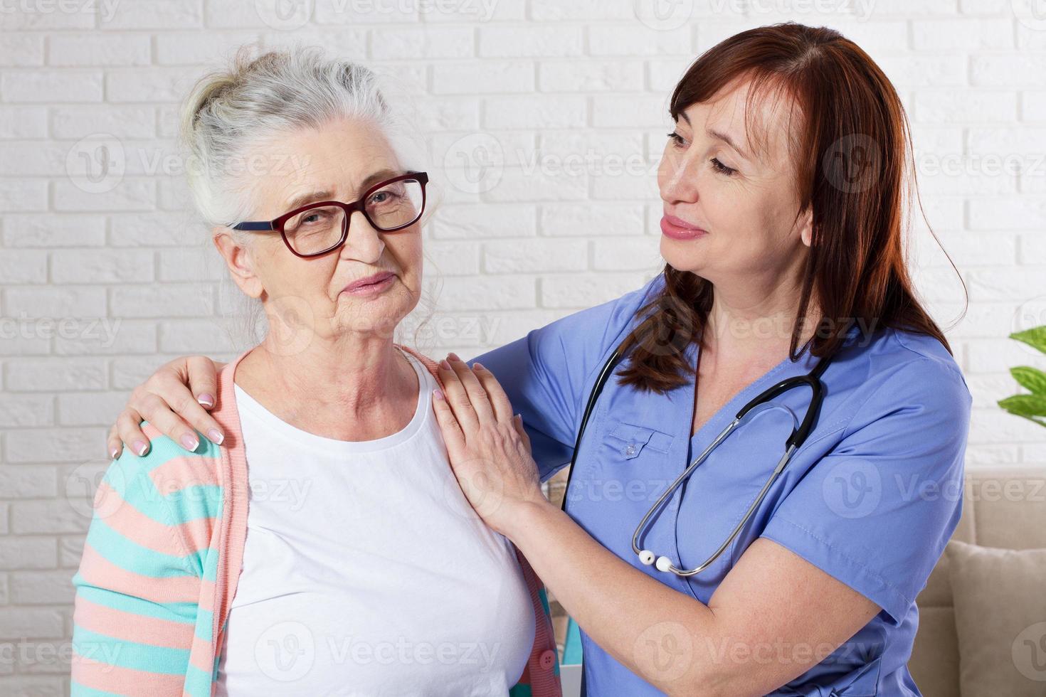 mulher sênior feliz com enfermeira em fisioterapia. foto