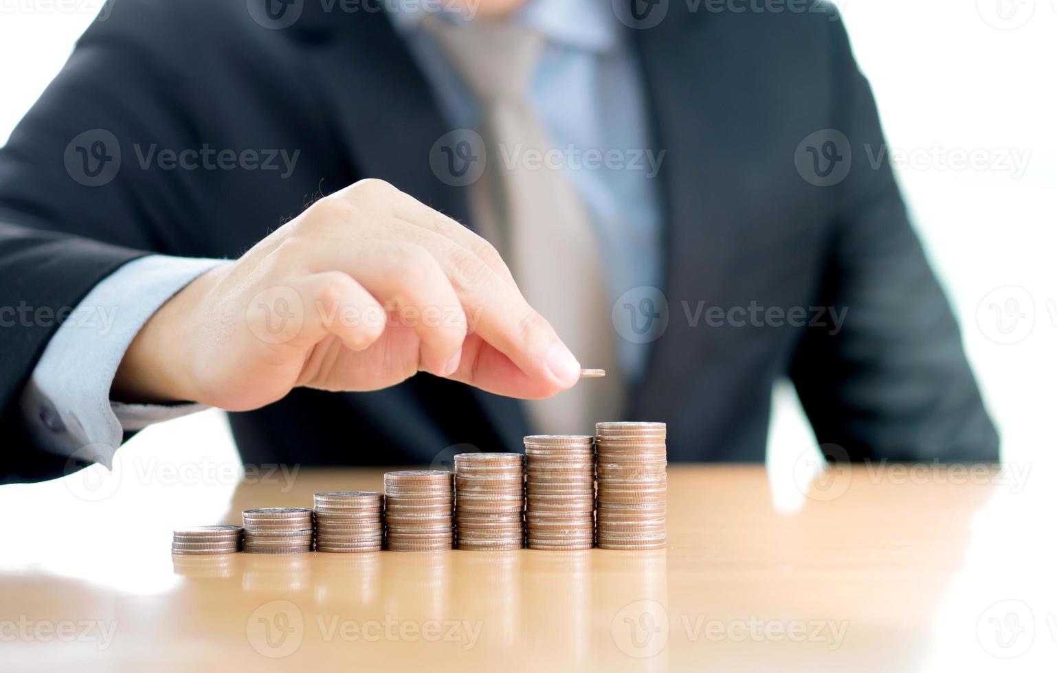 close-up de um empresário fazendo pilha de moedas foto